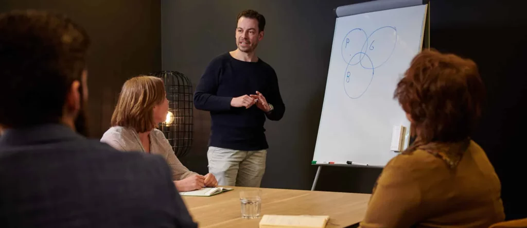 Man geeft uitleg voor een flip-over tijdens een les op de Cashflow-academy | Mr Cashflow.