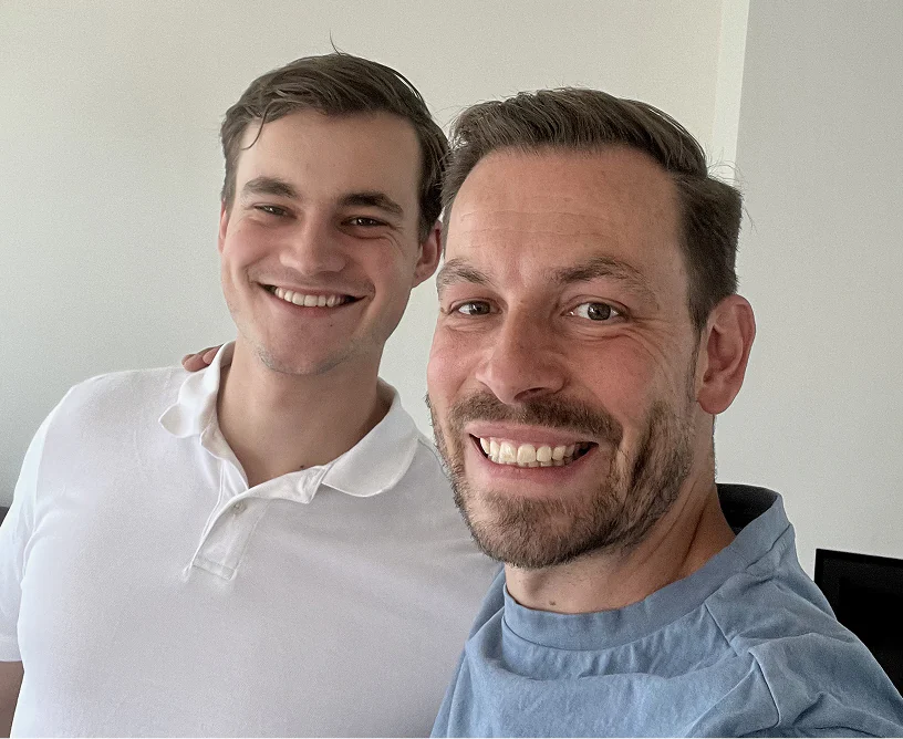 Mark en een blije ondernemer lachen samen voor de camera in een lichte ruimte | Mr Cashflow